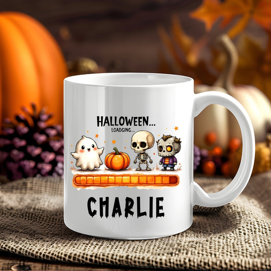 Personalised Halloween Loading Characters Halloween 11oz mug showing a ghost, jack-o'-lantern and spooky characters above an orange loading bar