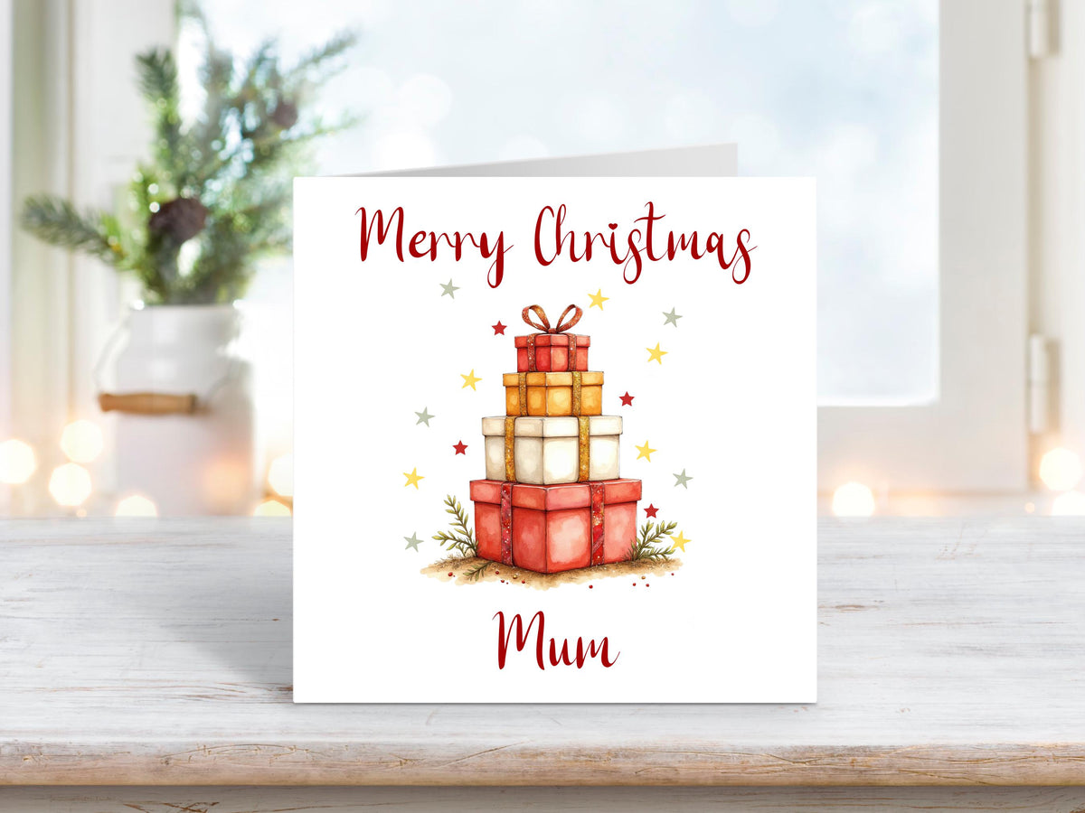 Christmas card featuring a tall stack of red and gold presents with the text “Merry Christmas Mum” on a white background.