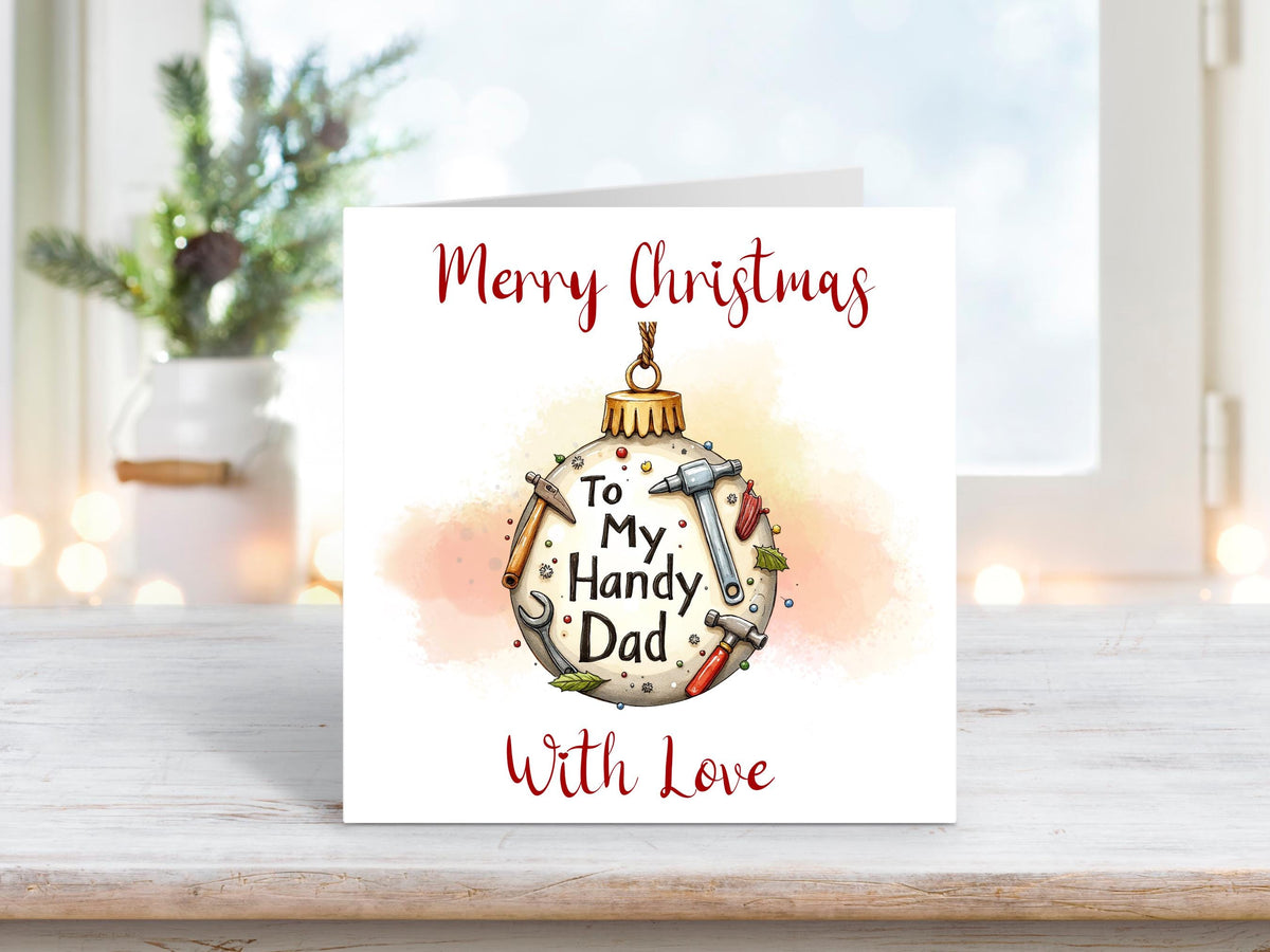 Christmas card featuring a bauble decorated with tools such as a hammer, wrench, and screwdriver, with the words “To My Handy Dad” and “Merry Christmas With Love.”