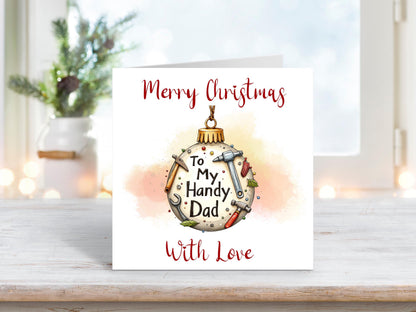 Christmas card featuring a bauble decorated with tools such as a hammer, wrench, and screwdriver, with the words “To My Handy Dad” and “Merry Christmas With Love.”