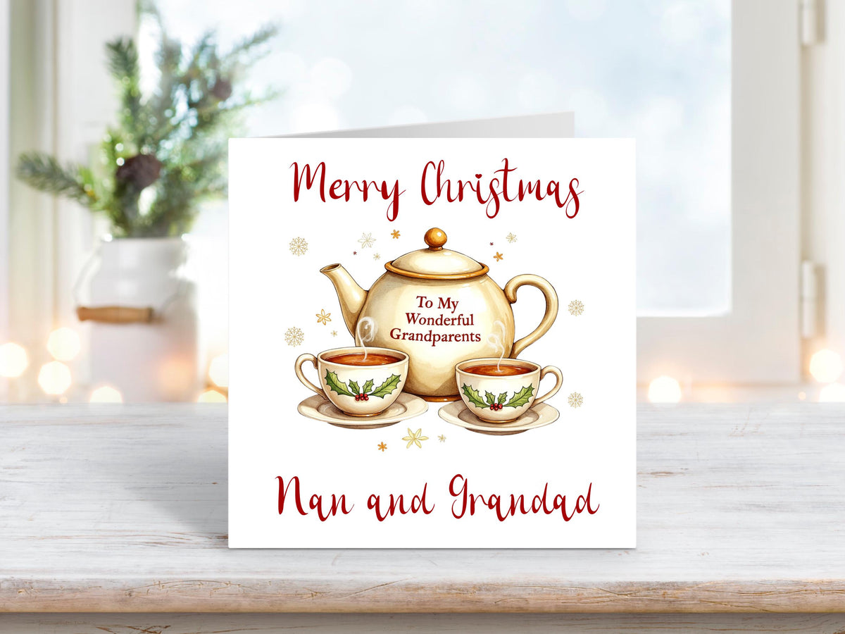 Christmas card featuring a festive teapot with the words “To My Wonderful Grandparents” and two holly-decorated teacups, surrounded by golden snowflakes, with “Merry Christmas Nan and Grandad” written above and below.