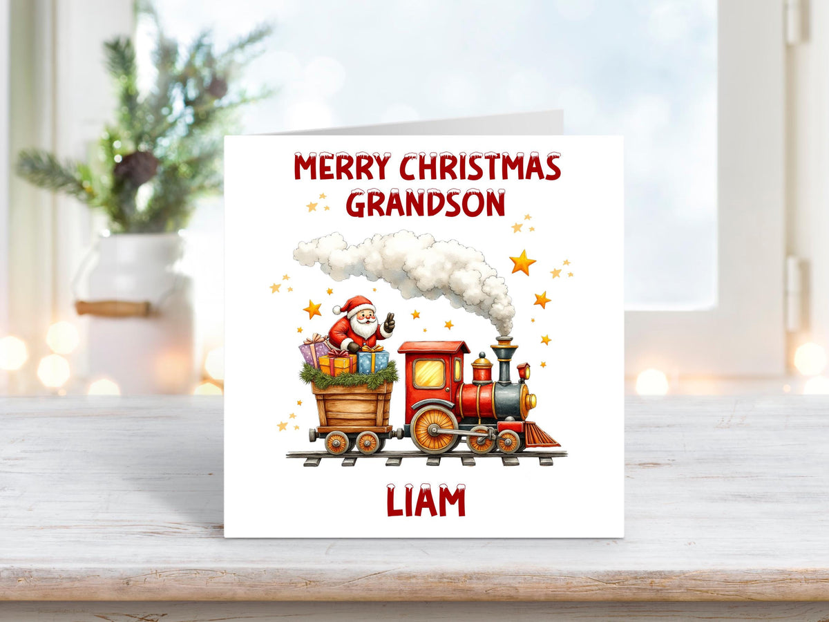 Personalised Christmas card for a grandson featuring Santa riding a red and yellow steam train filled with presents, with stars and smoke in the background.