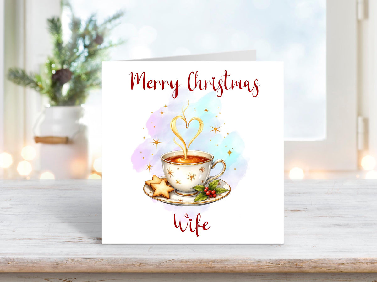 Christmas card for wife showing a warm festive drink in a teacup with heart-shaped steam, stars, and holly.