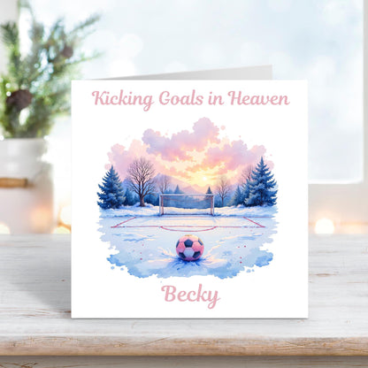 Memorial card showing a pink and purple football resting on a snowy pitch at sunrise, with the text “Kicking Goals in Heaven” and personalised name “Becky.”