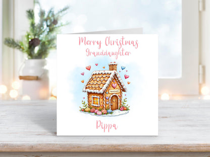 A sweet Christmas card for a granddaughter, featuring a pastel gingerbread house with heart decorations and personalised with her name.