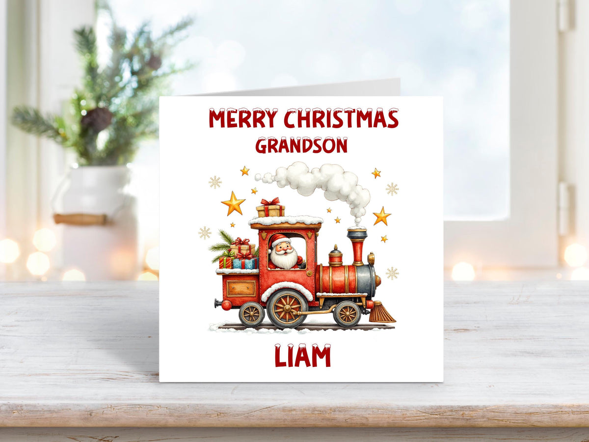 Christmas card for grandson with Santa Claus driving a red festive train, steam rising, and loaded with wrapped presents and golden stars.