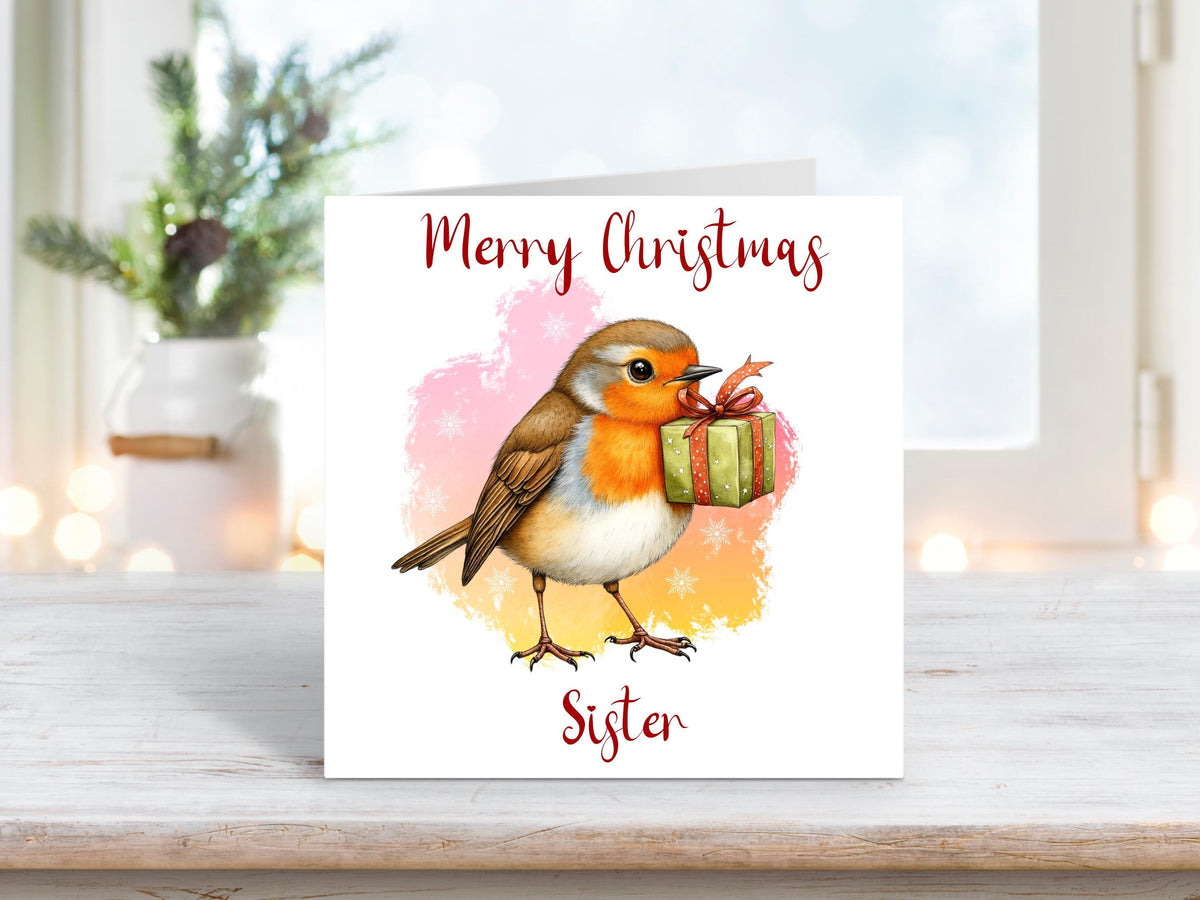 Christmas card for sister featuring a robin holding a green present in its beak, with a pink and yellow snowy background.