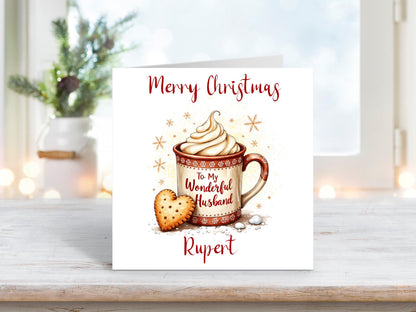 Christmas card for husband featuring a festive mug of hot chocolate with cream and a heart-shaped biscuit, personalised with his name.