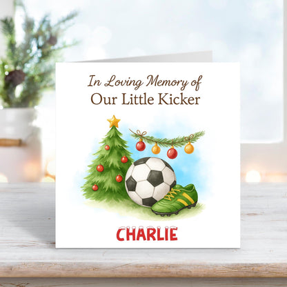 Memorial Christmas card showing a football, green boots, and a decorated tree under the text “In Loving Memory of Our Little Kicker,” personalised with the name Charlie.