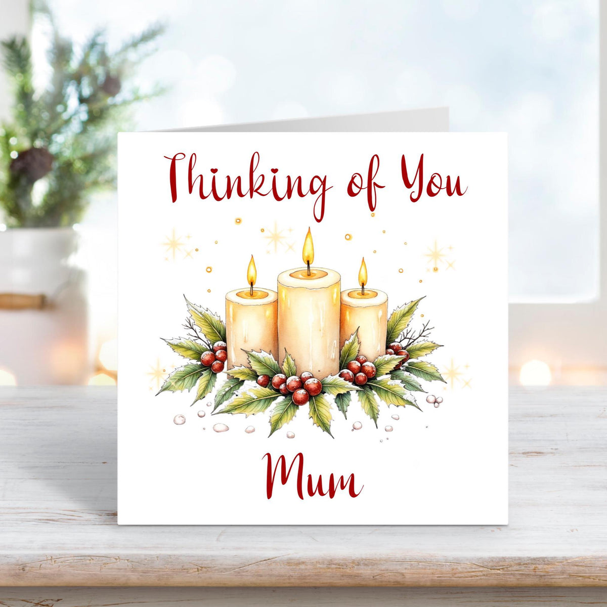 Christmas card featuring three glowing candles surrounded by holly and berries, with the words “Thinking of You Mum” on a white background.
