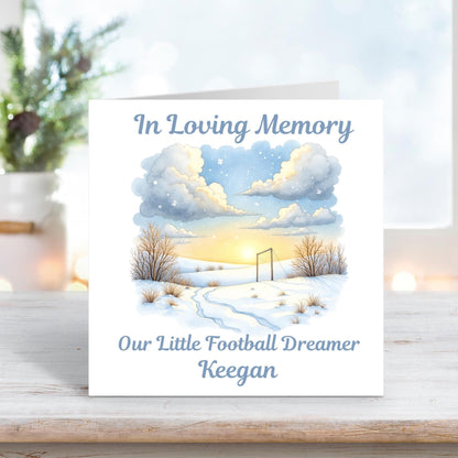 Memorial card featuring a peaceful snowy football field at sunset with the words “In Loving Memory – Our Little Football Dreamer Keegan.”