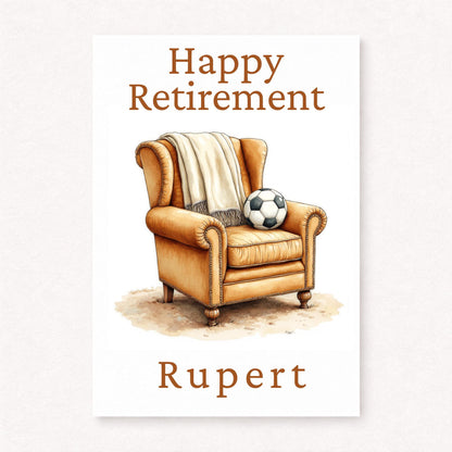 Personalised football retirement card with armchair, blanket and football, happy retirement text and custom name in warm classic tones