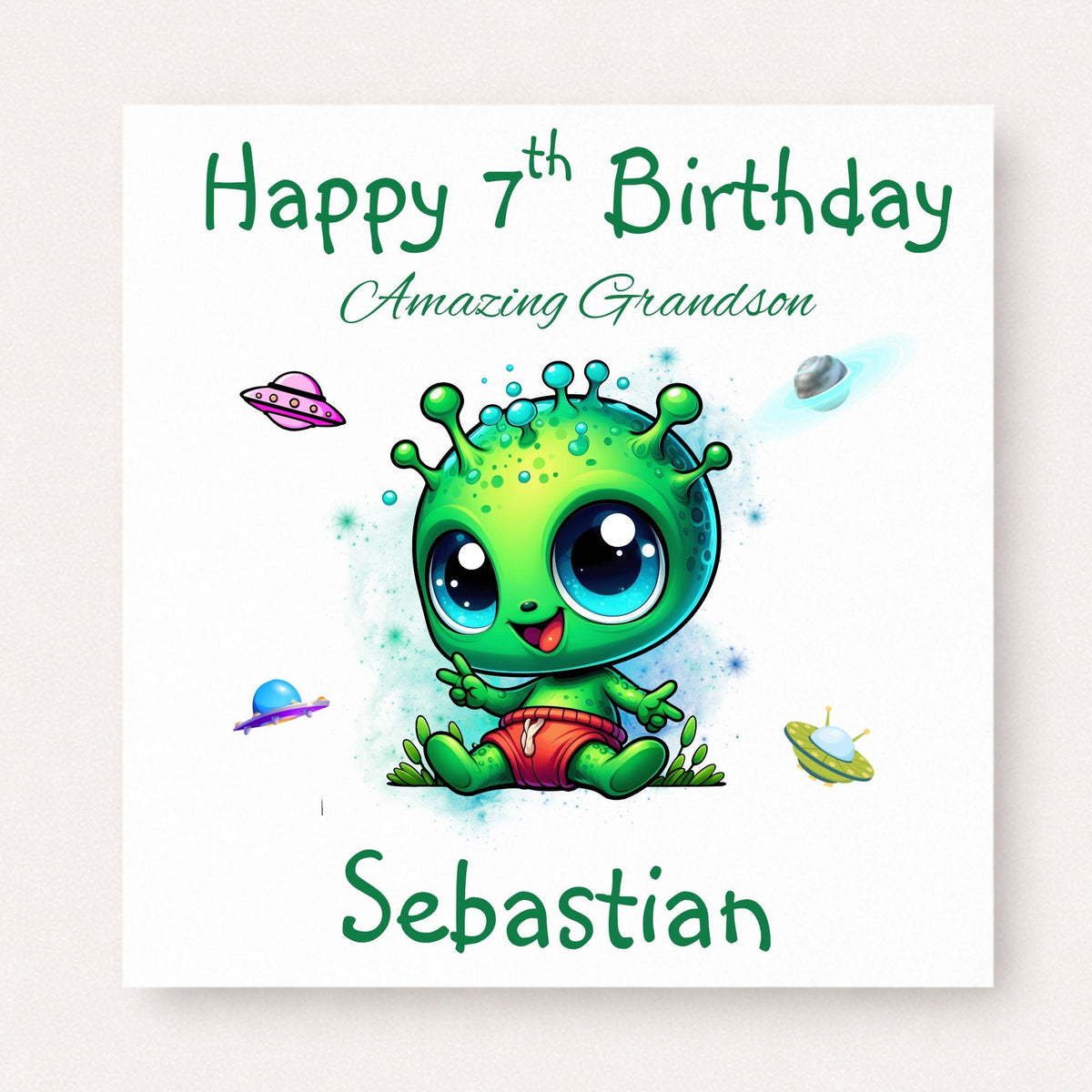 Personalised 7th birthday card for grandson featuring a cute bright green alien surrounded by colourful spaceships, customised with his name.