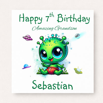 Personalised 7th birthday card for grandson featuring a cute bright green alien surrounded by colourful spaceships, customised with his name.